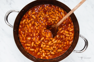Vegan baked beans, cooking in a pan on the stove.