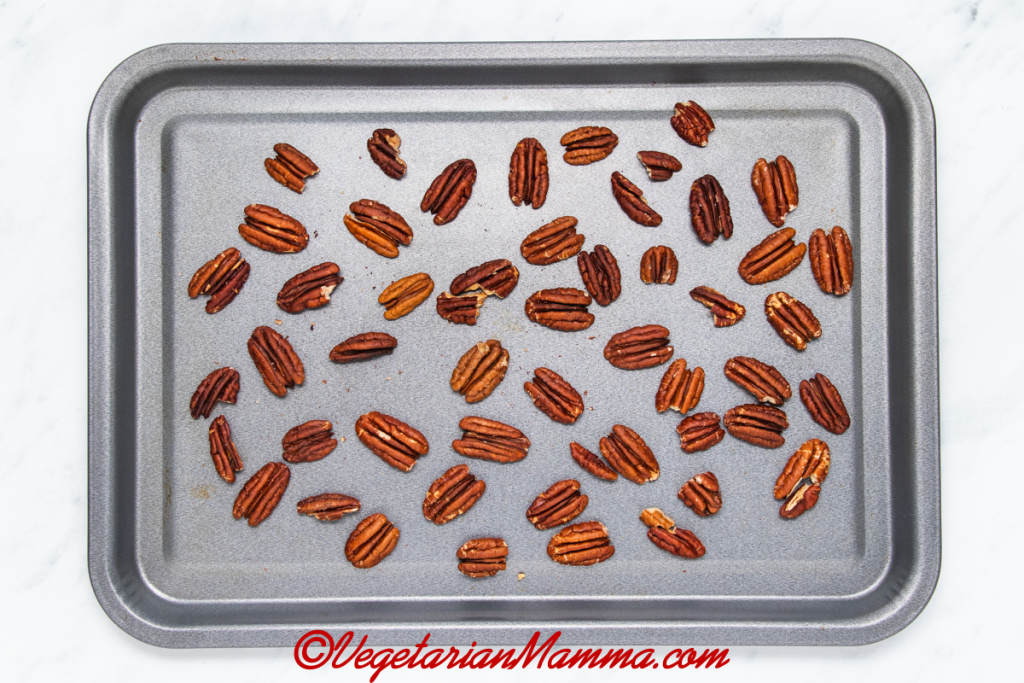 Pecans halves placed on a baking sheet for roasting.
