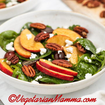 Apple pecan salad with feta cheese in a white bowl.