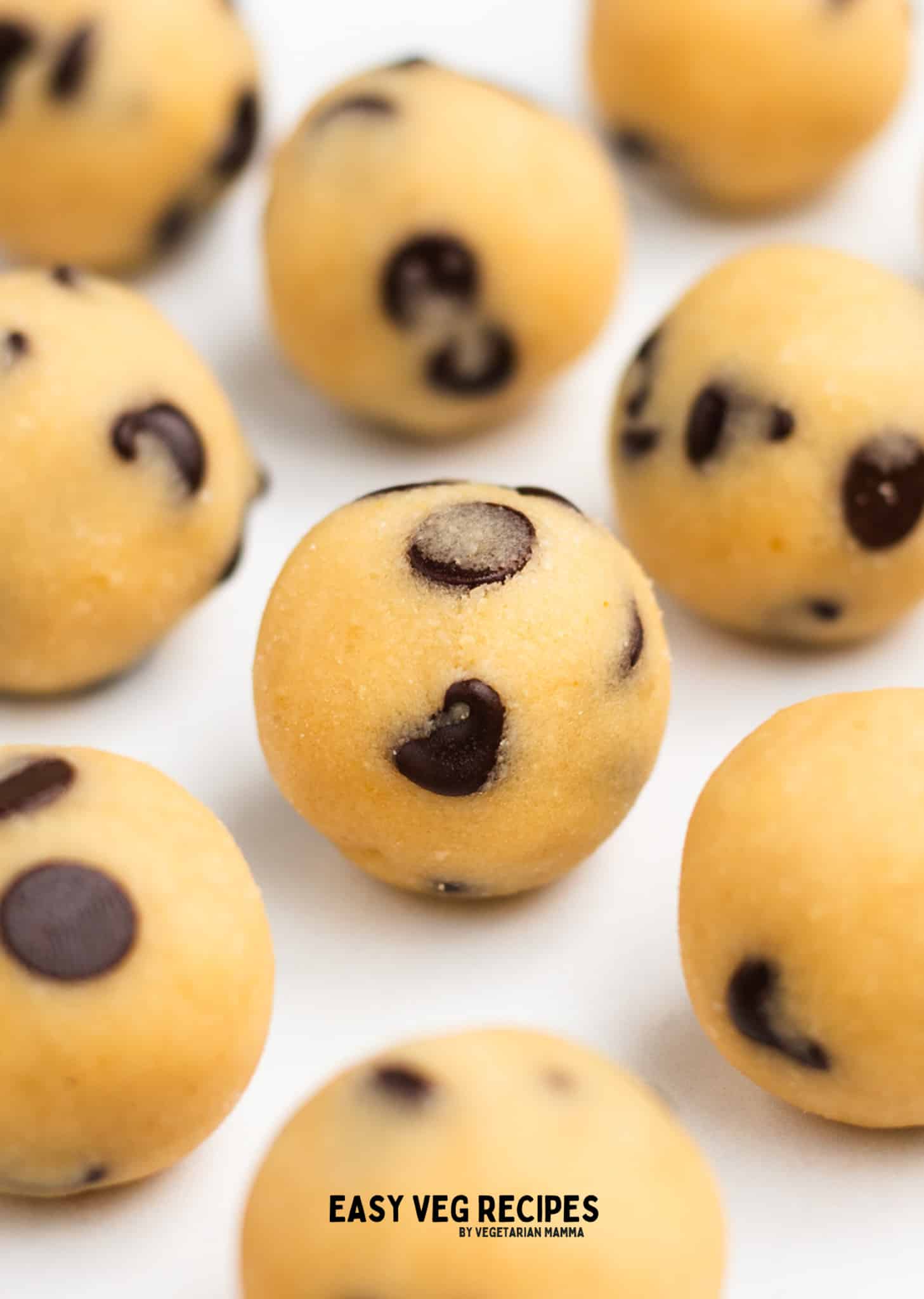 round cookie dough balls on a white surface.