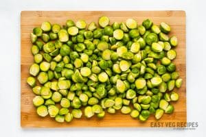 trimmed brussel sprouts on a wooden cutting board.