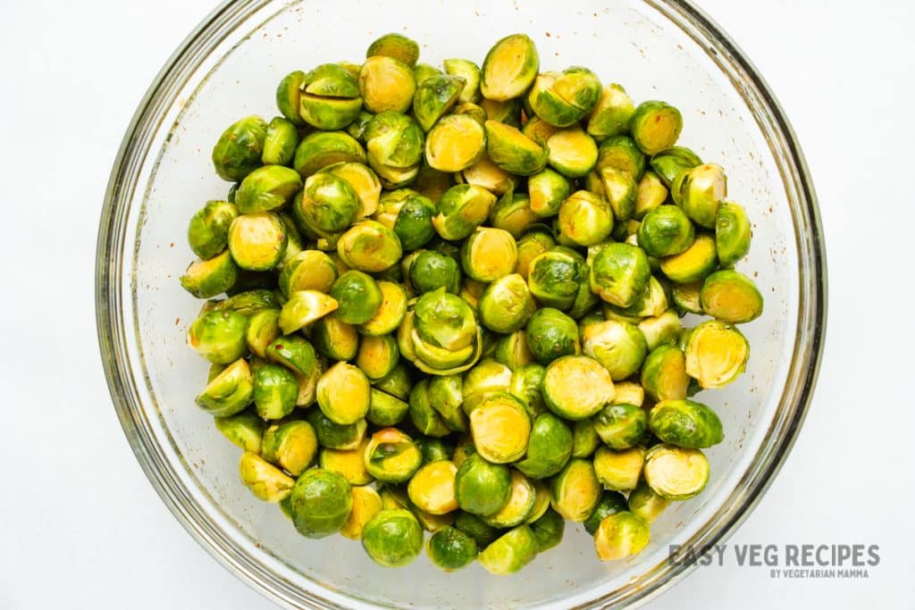 uncooked brussel sprouts in a glass bowl.