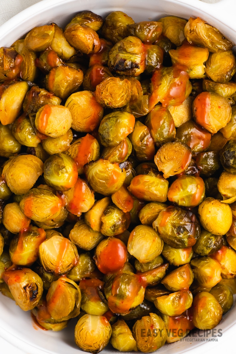 roasted brussel sprouts with honey sriracha sauce, in a large bowl, viewed from above.