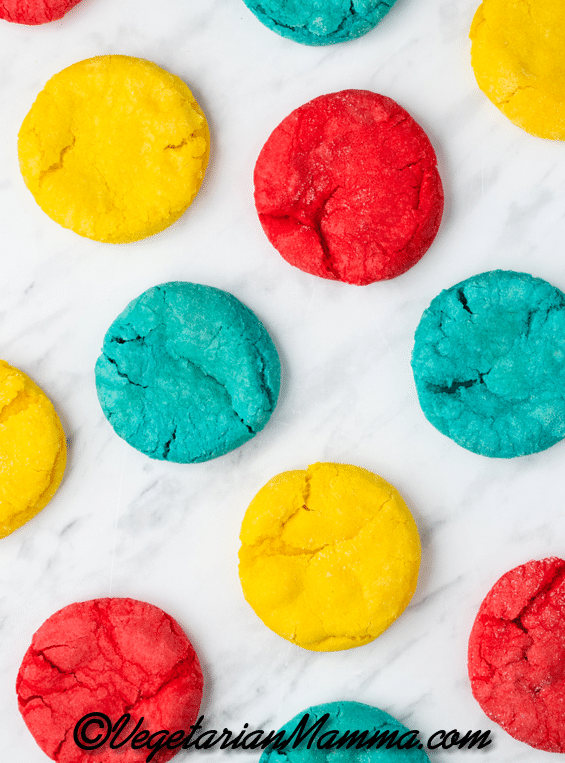 red, blue, and yellow sugar cookies on a marble counter. 