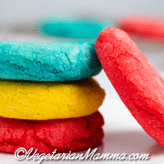 A stack of Mexican sugar cookies in blue, yellow, and red.