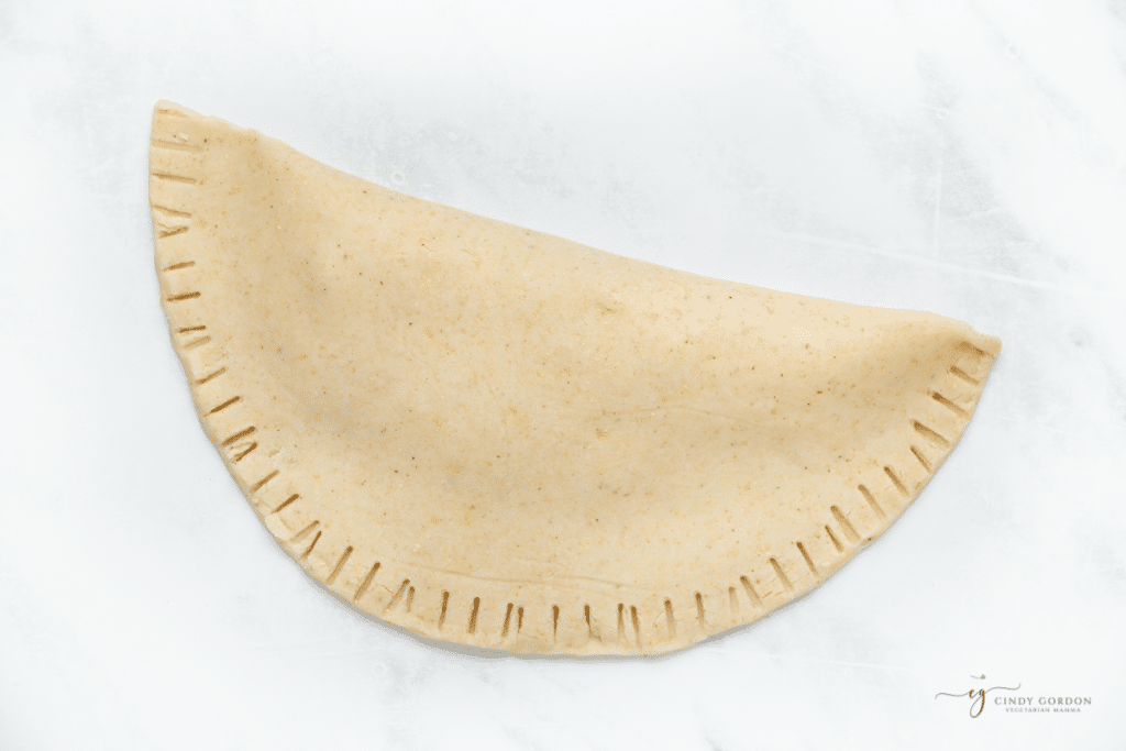 a folded fresh tortilla with the edges crimped with a fork.