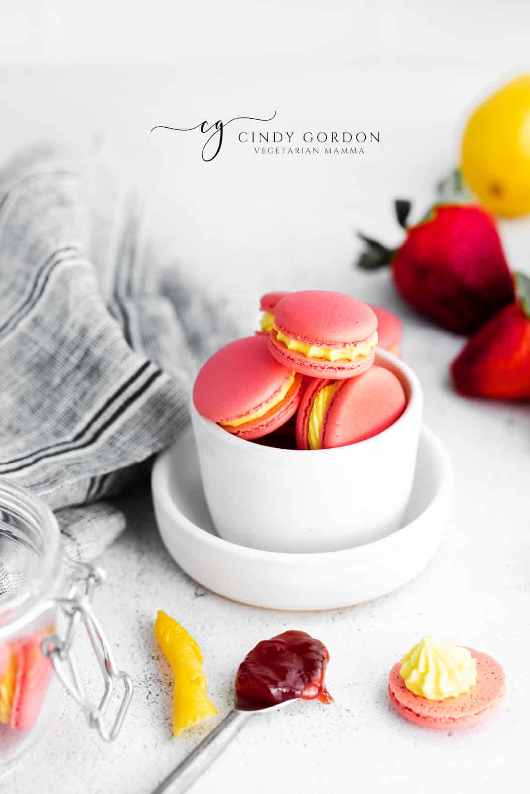 a bowl of dark pink strawberry macarons with lemon filling. 