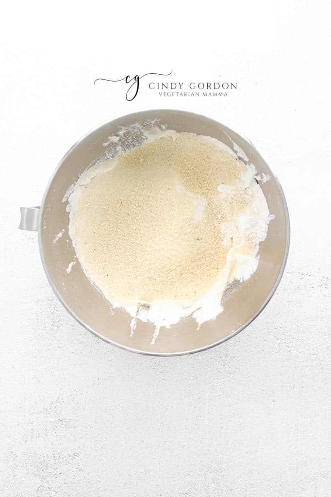 almond flour sifted into a bowl of whipped egg whites