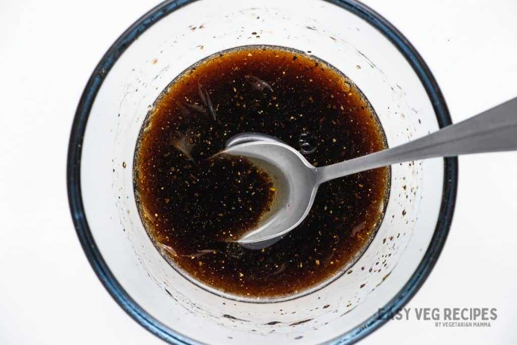 homemade dressing for watermelon salad, in a small glass bowl with a spoon