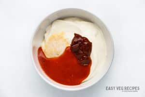 Sour Cream, chipotle paste, hot sauce, in a bowl.