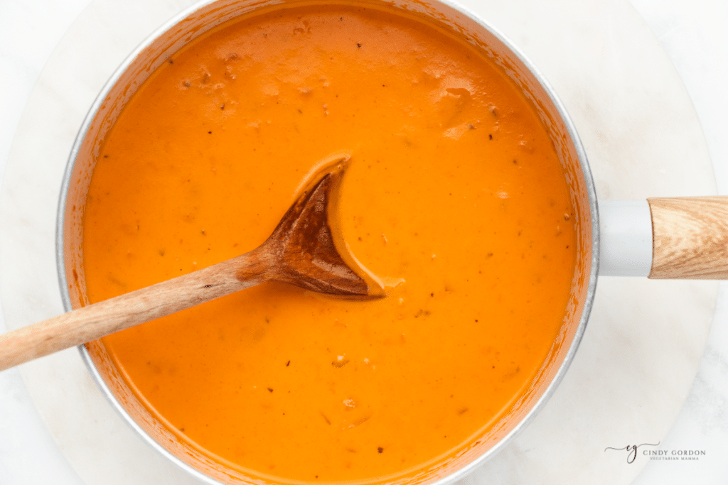 Palomino sauce cooking in a small saucepan, stirred with a wooden spoon.