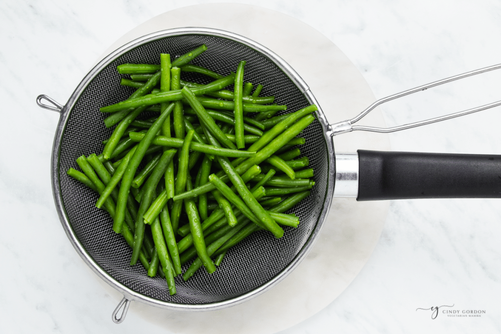 Blanched beans drained with a mesh colander.