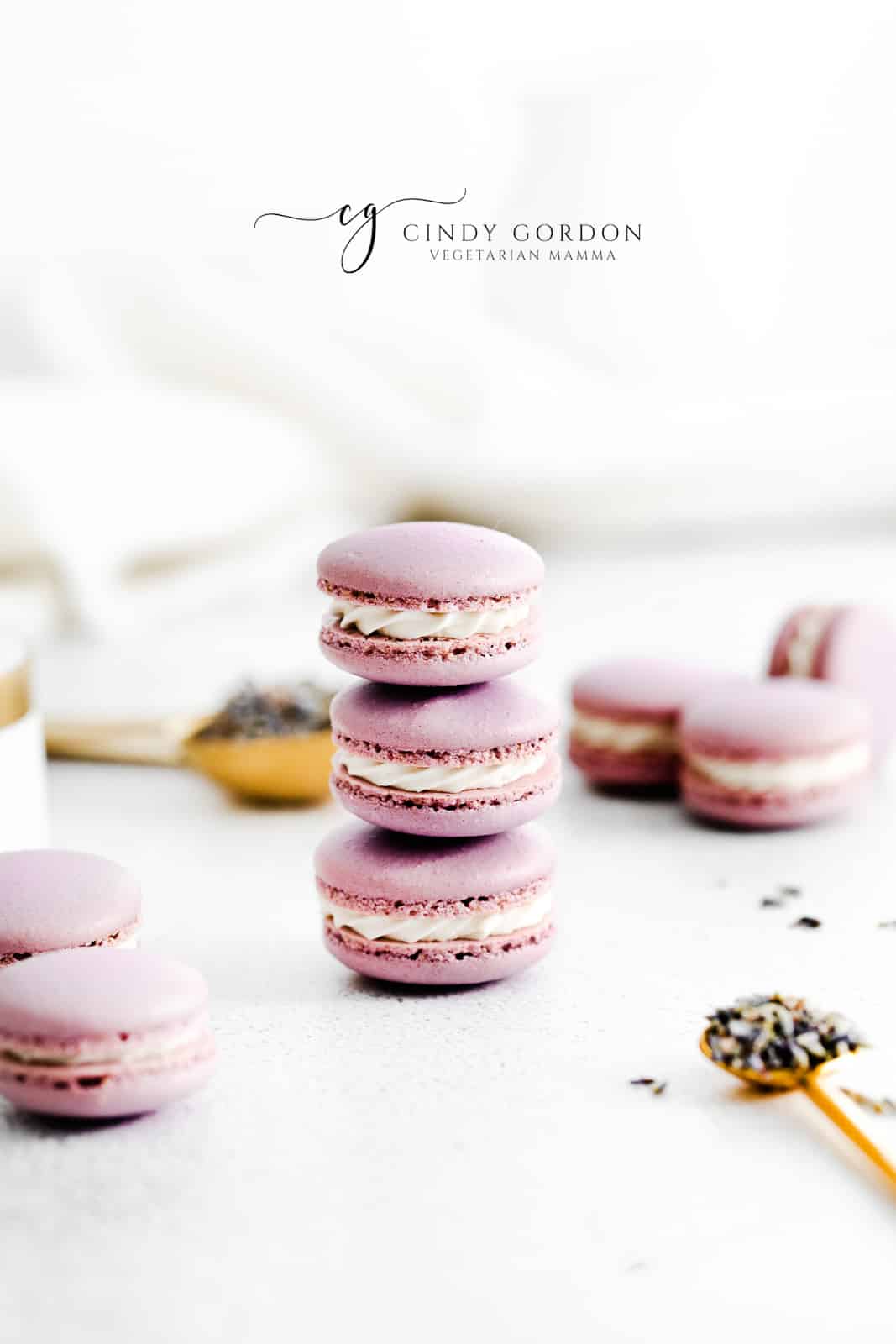 a stack of three purple macarons with dried lavender buds