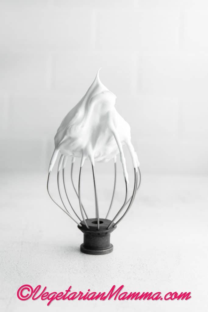 wire whisk with egg whites on the edge