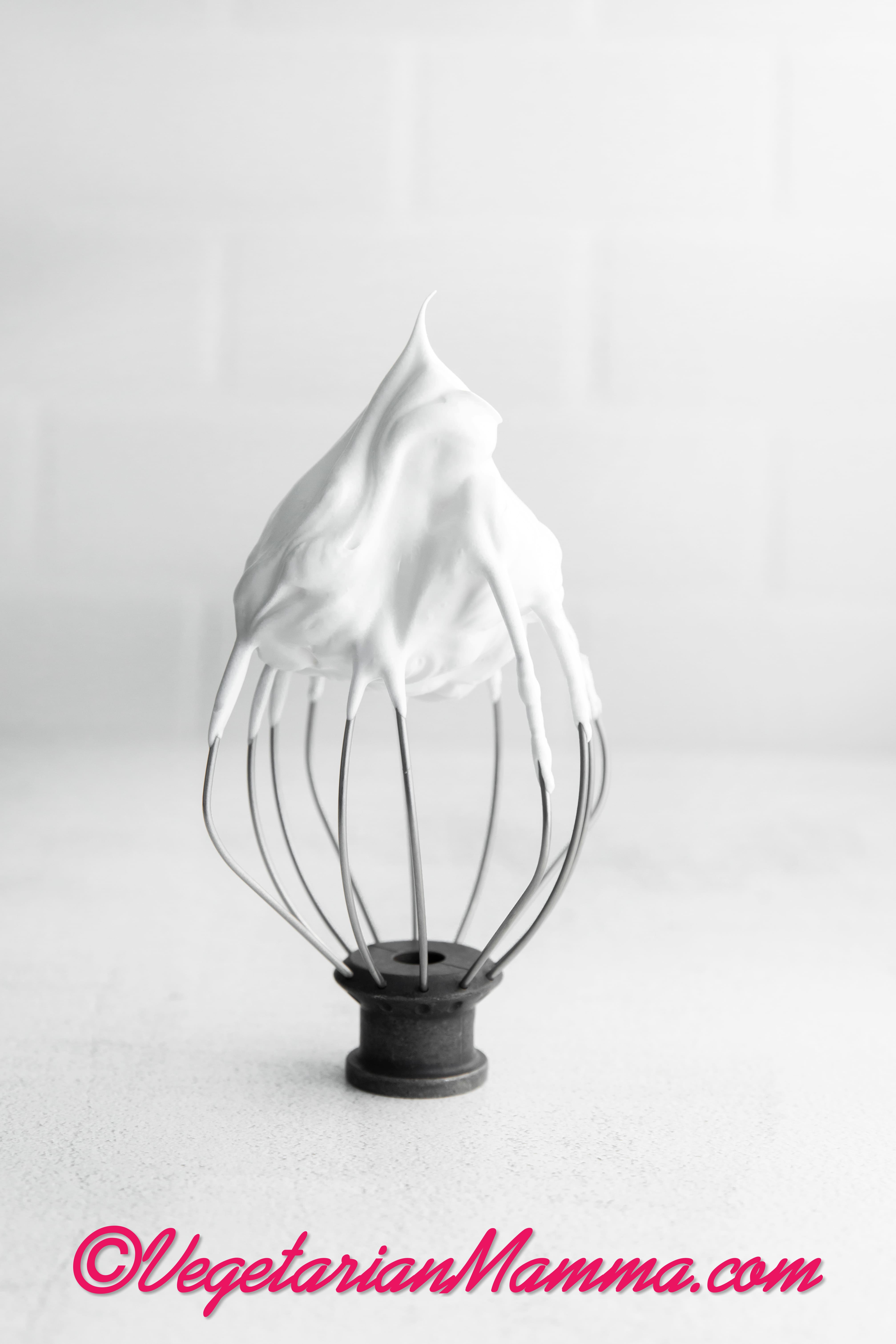 a wire beater showing what stiff peak egg whites should look like.