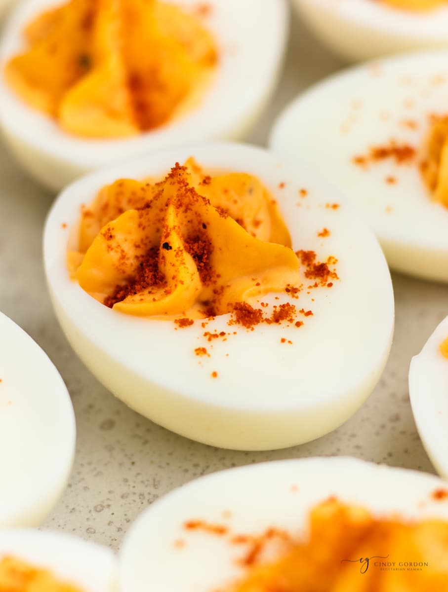 closeup of million dollar deviled eggs with star piped filling and paprika sprinkle. 