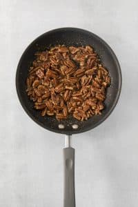 candied pecans in a nonstick skillet, viewed from above.