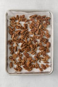 candied pecans spread out on a pan.