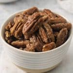 a white bowl filled with homemade candied pecans