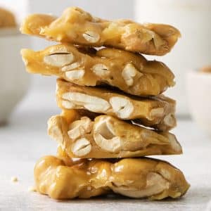 5 pieces of homemade cashew brittle, stacked on top of each other.