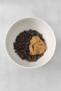 a bowl of dark chocolate chips and peanut butter.