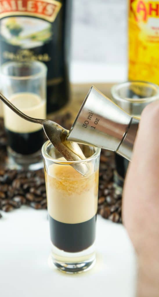 whisky poured gently over a spoon into a duck fart shot.