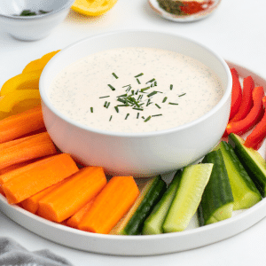 a platter of veggies surrounding a bowl of seasoned sour cream dip