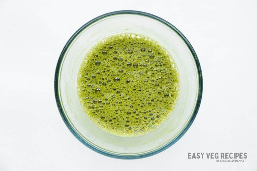matcha powder whisked into hot water in a bowl.