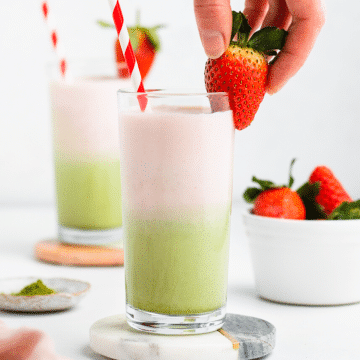 a layered strawberry matcha latte in a tall glass