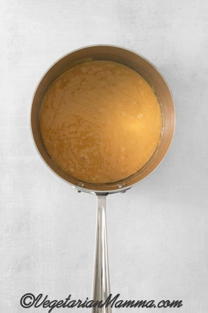 Once the syrup reaches the hard crack stage, remove the saucepan from heat. Quickly add the butter, vanilla extract, and baking soda. Stir to combine.