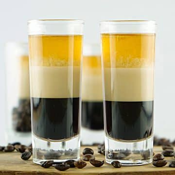 Two tall shooter glasses with layered duck fart shots.