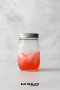 a mason jar with ice and cosmo, after shaking.