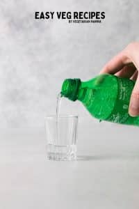 sprite soda pouring into a small shot glass.