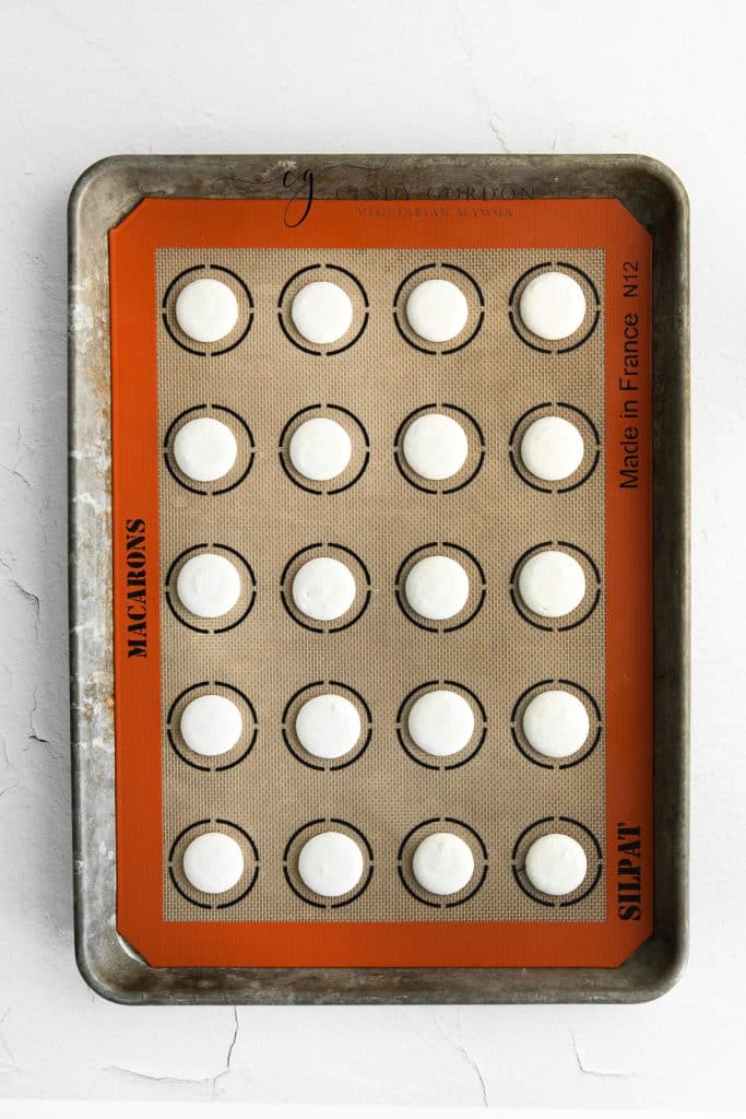 raw macaron shells piped onto a silpat.