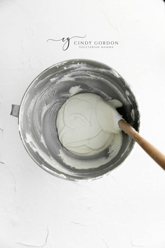 macaron batter in a bowl, with a spatula.