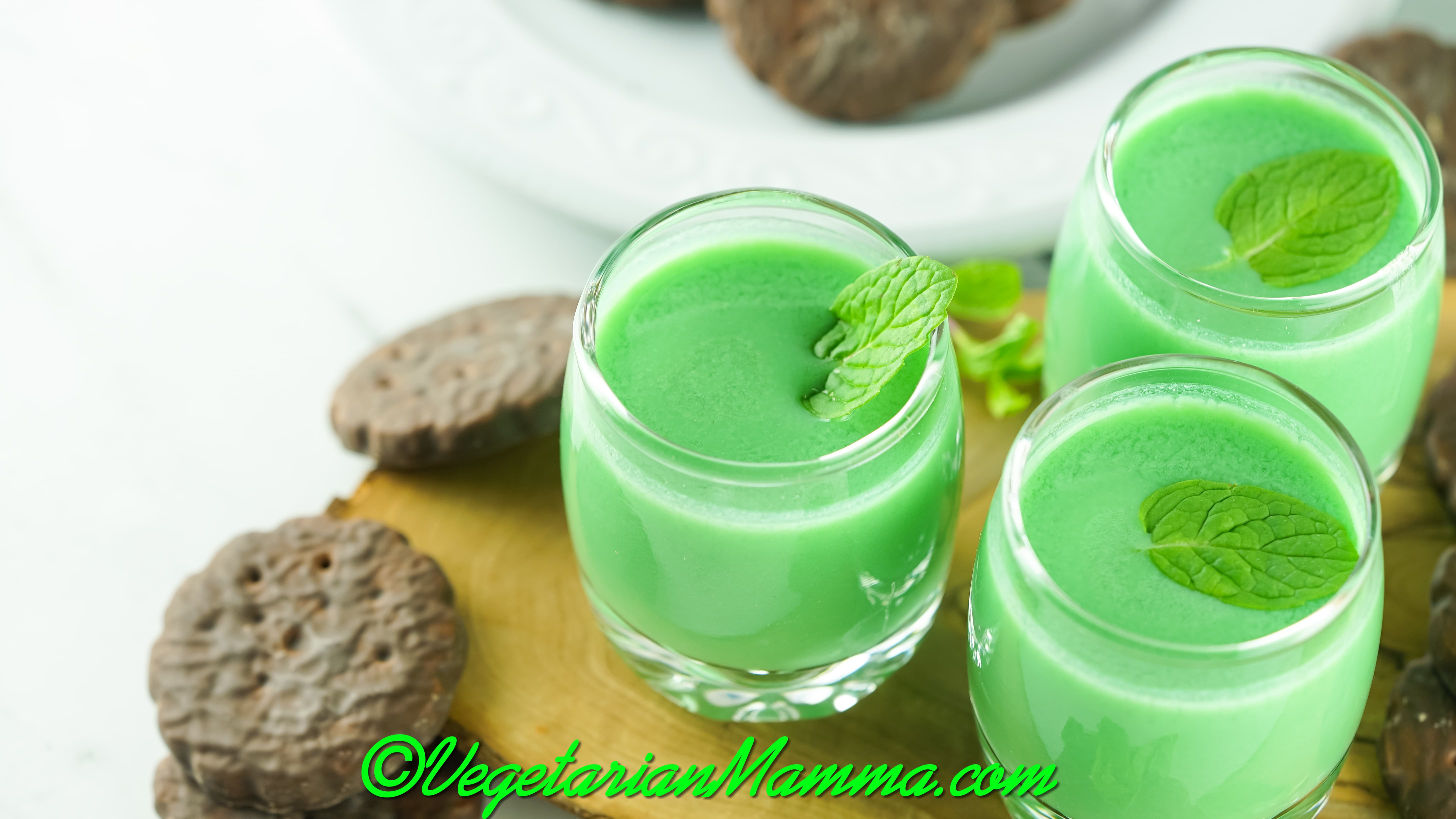 small glasses filled with creamy green dirty girl scout shots, garnished with mint leaves