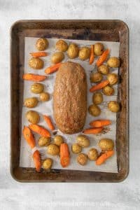 Carrots and potatoes surrounding the roast.