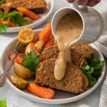 pouring gravy over sliced meatless roast beast.