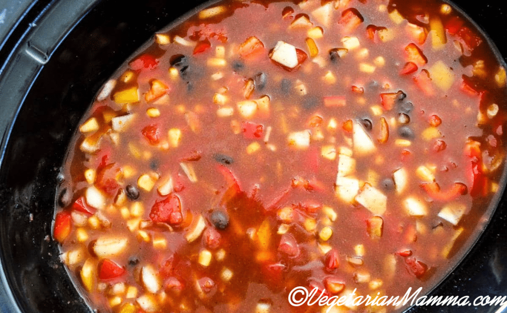 combination of corn, tomatoes, enchilada sauce, black beans mixed in the crockpot.