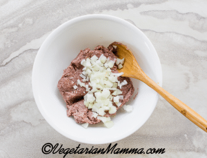 A white bowl with Beyond Meat and diced onions.
