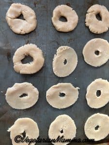 doughnut shaped discs on a baking sheet ready for the oven.