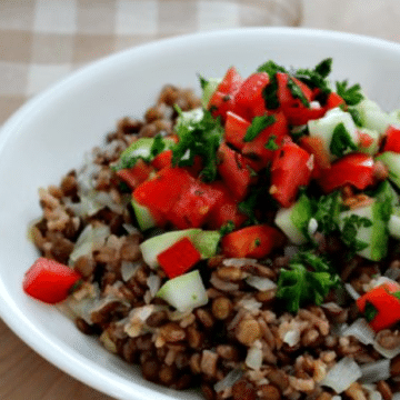 A heaping bowl of Judara with rice and lentils topped with cucumbers and tomatoes.