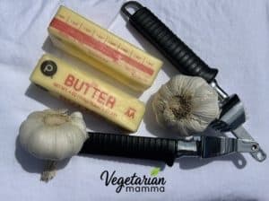 2 sticks butter, 2 garlic bulbs, and a garlic press