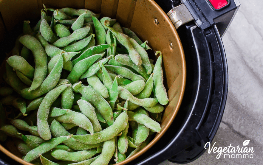 An air fryer filled with edamame ready to be fried for a delicious snack.