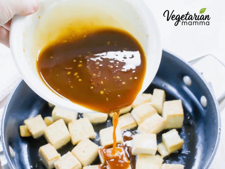 Sticky, sesame sauce poured over the crispy tofu in a pan.